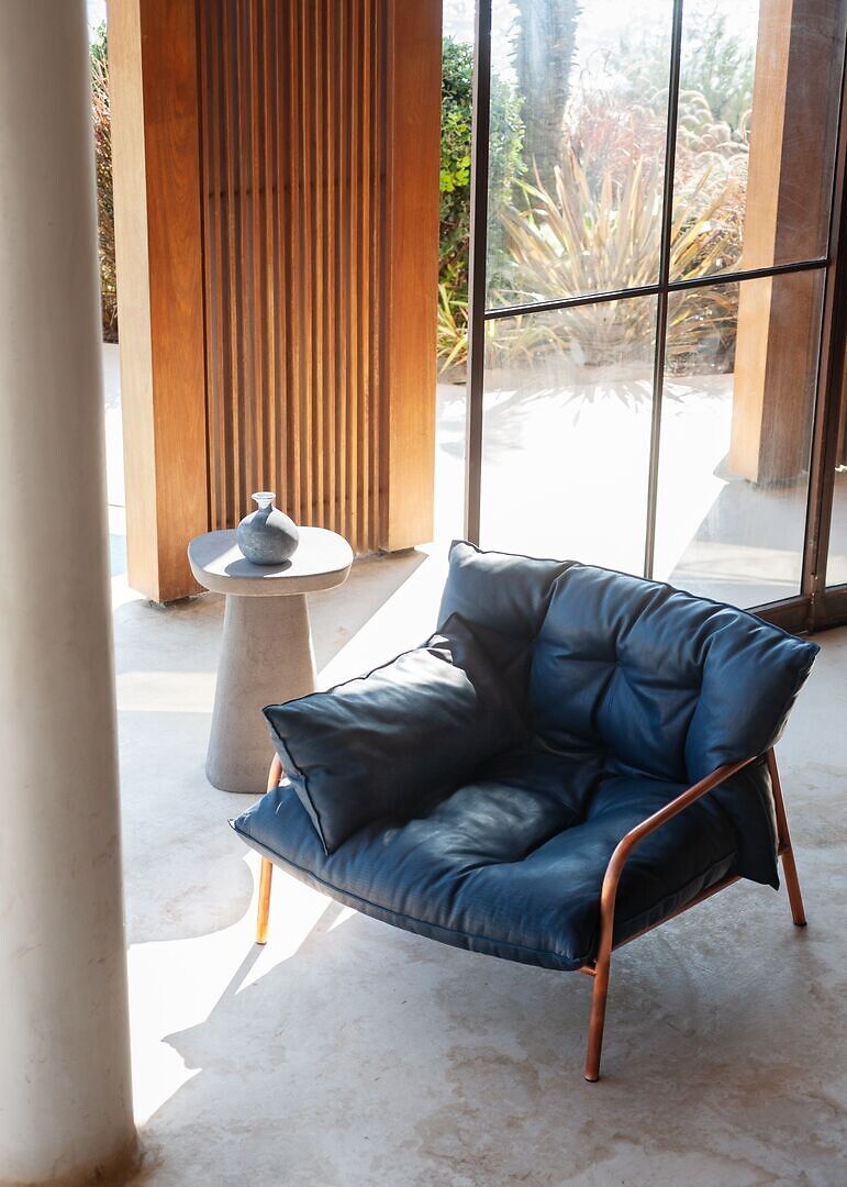 Tiefer Loungesessel aus schwarzem Leder mit organisch gebogener Rückenlehne