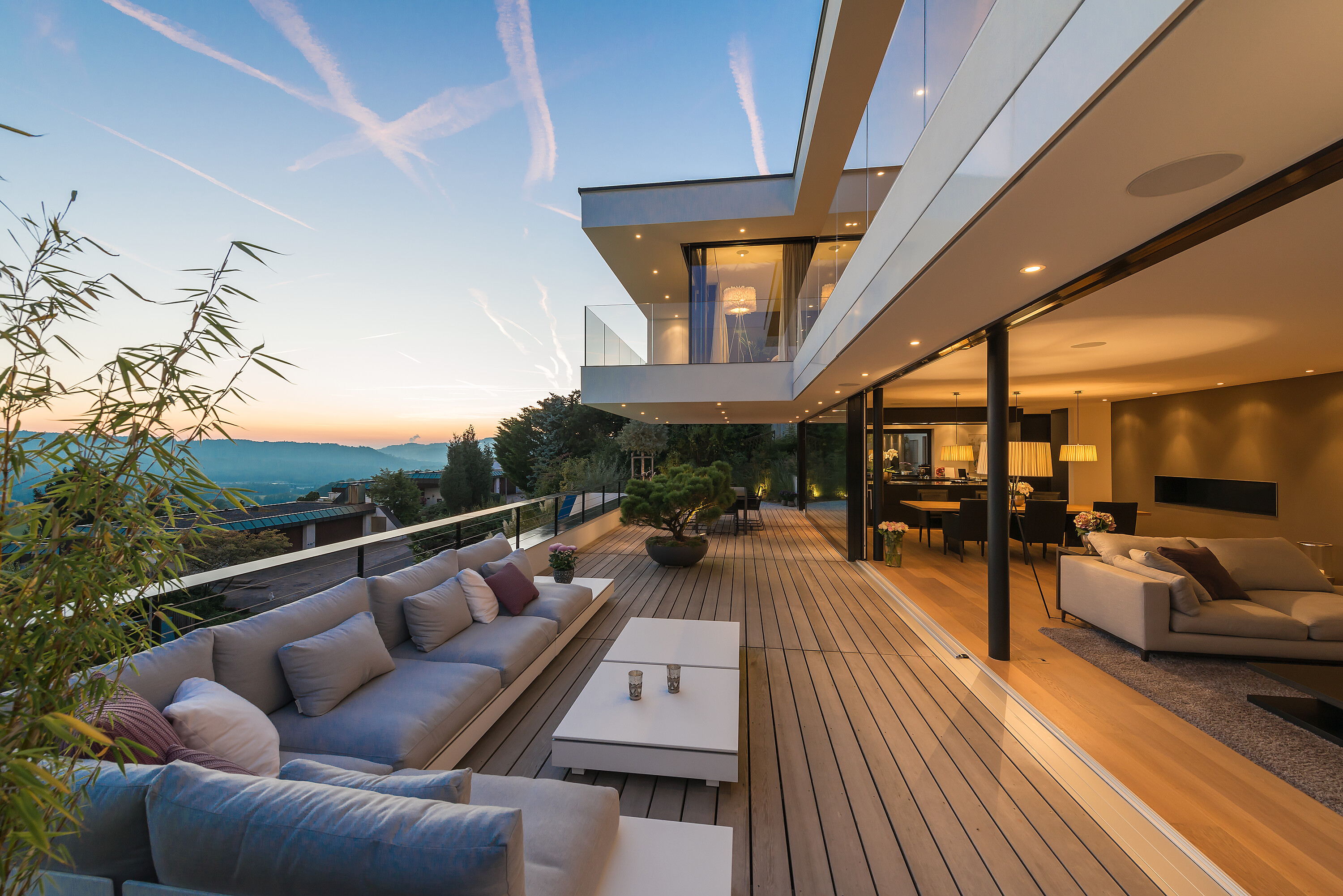 Das Zusammenspiel von offenen und geschlossenen Elementen definiert den Neubau, der von den Architekten Definti Brunner realisiert wurde. Passend dazu wurde der Außenbereich mit geradlinigen Möbeln eingerichtet, die diesen Stil weiter ausführen.