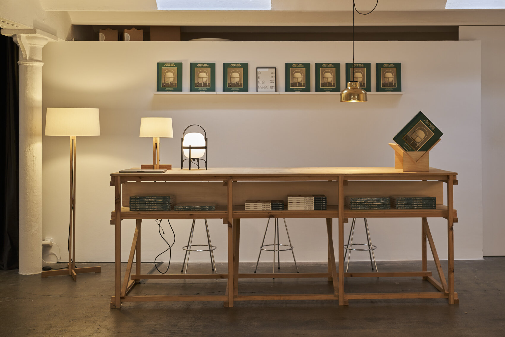 Ausstellungsraum von Santa & Cole mit Leuchten von Miguel Milá und Holztresen