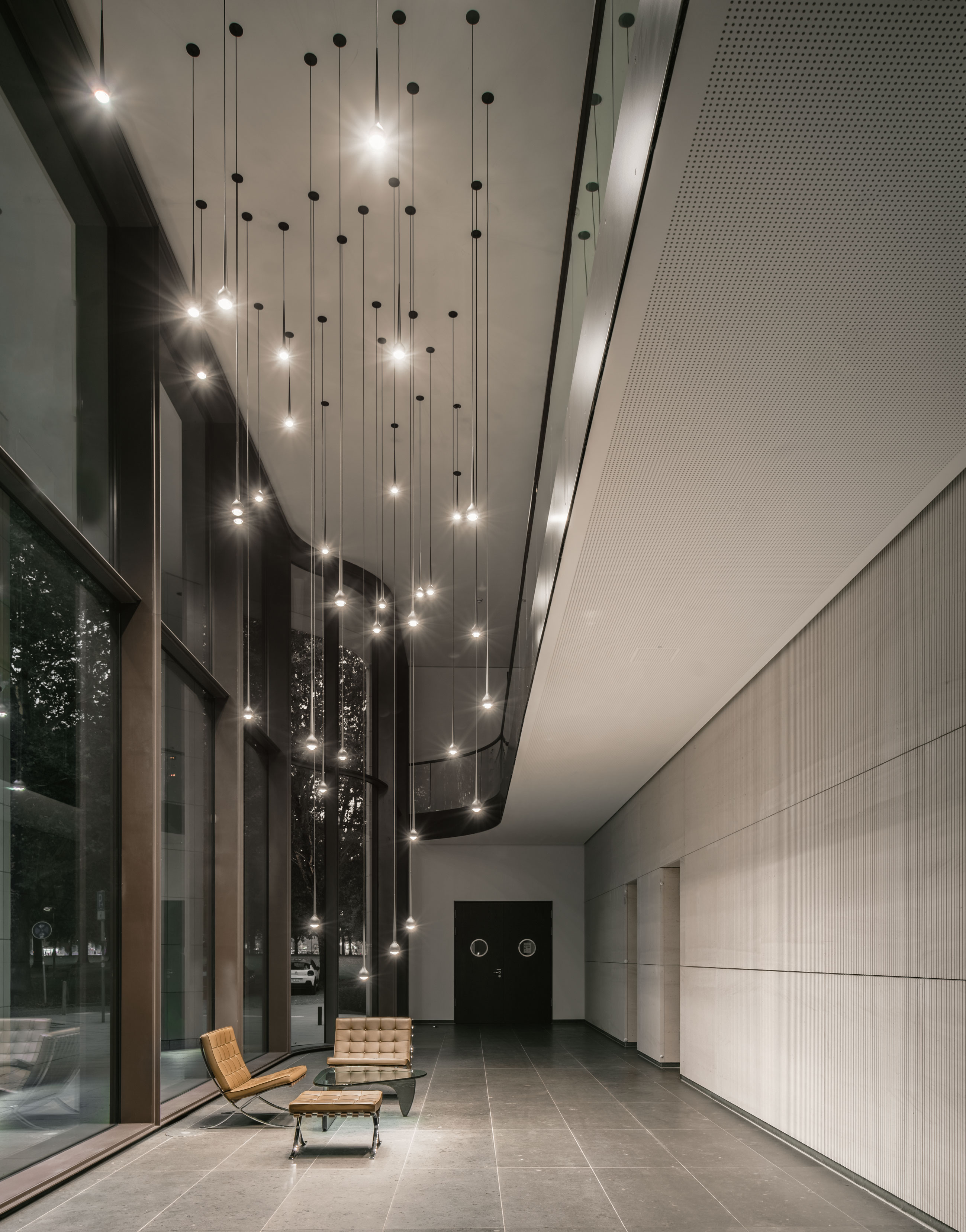 Mehrere Pendelleuchten Falling Water von Grau in hoher Lobby mit Glasfassade