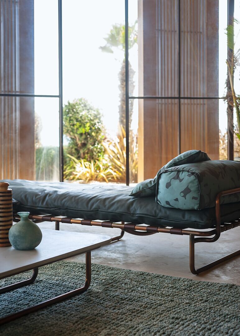 Tagesbett mit grünem Polster und Kissen