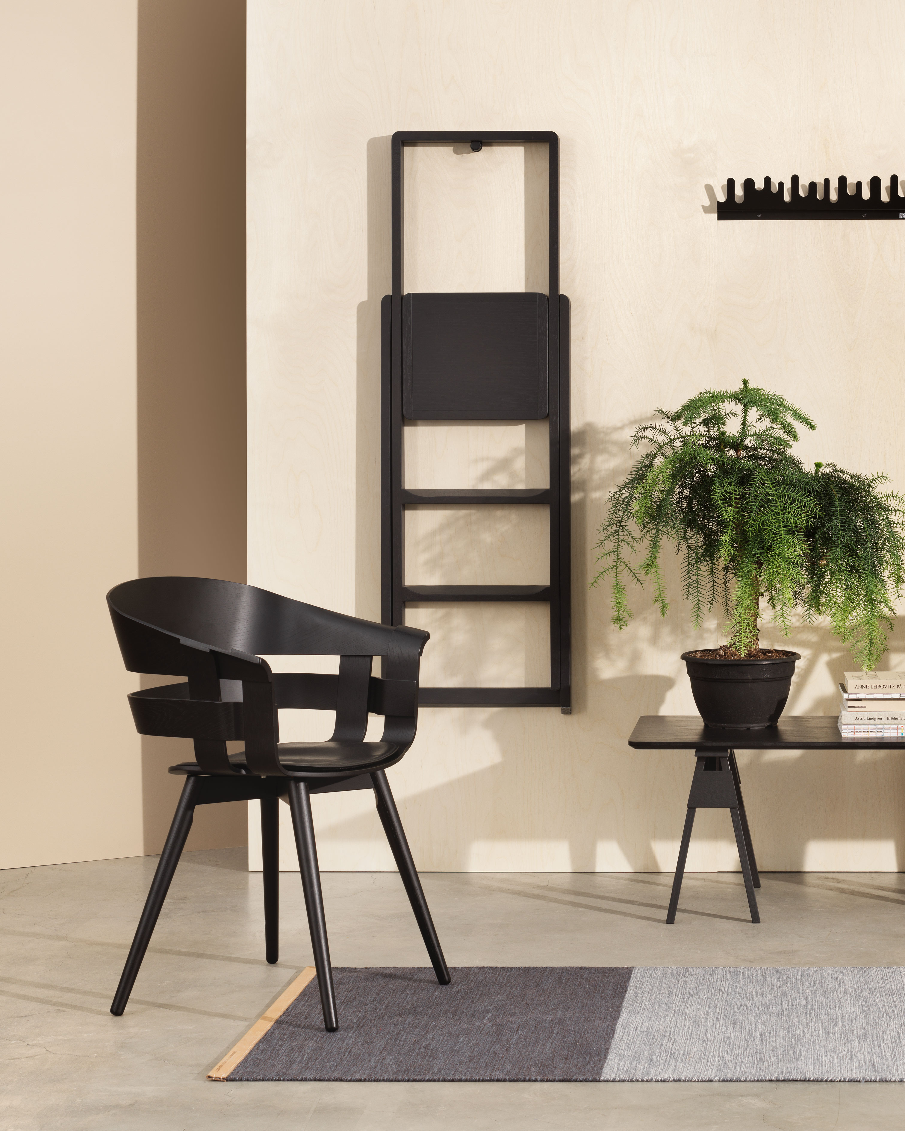 Kompakte Trittleiter Step von Design House Stockholm in eingeklappter Wandposition Schwarze Trittleiter Step von Design House Stockholm hängend an der Wand in Wohnraumszene